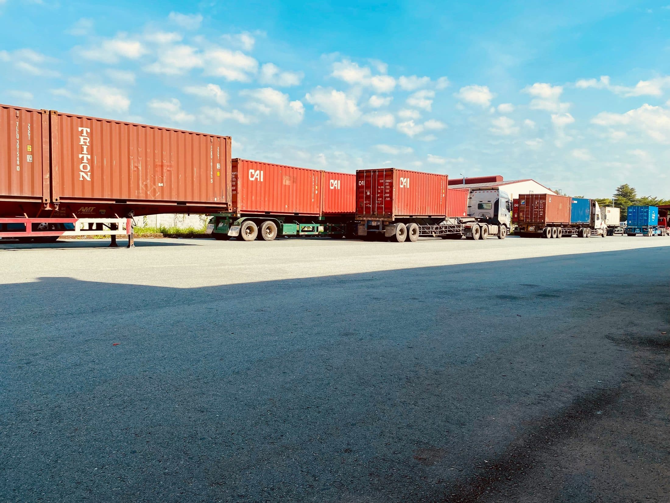 A line of freight trucks loaded with shipping containers